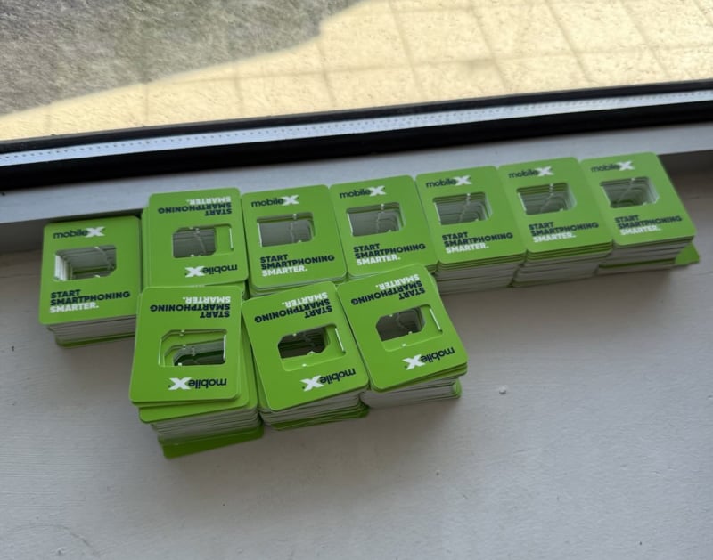 Large stacks of MobileX SIM card packaging.