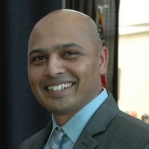 Professional man at Black Hat 2026 event, smiling in a suit.