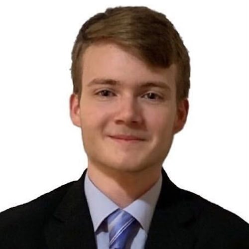 Young man in formal suit smiling, professional appearance.