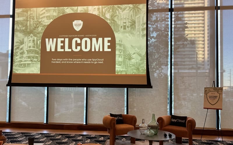 Welcome screen for SpyCloud Customer Advisory Board event in a modern conference room.